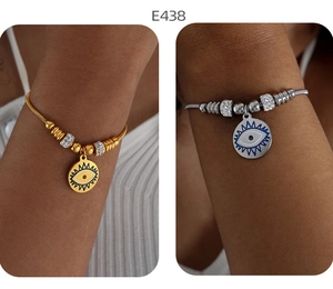 Detail von Gold- und Silber-Armbändern mit Evil-Eye-Anhängern und Kristallperlen