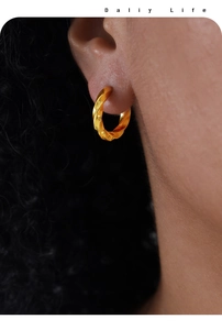 Vue macro de boucles d'oreilles torsadées en plaqué or montrant les détails fins