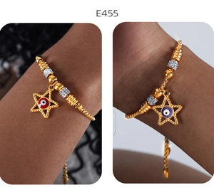 Detail von 18k Goldperlen-Armband mit Stern und Auge-Amulett am Handgelenk