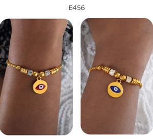 Detailansicht der 18K vergoldeten Evil Eye Armbänder mit Emaille-Anhängern am Handgelenk