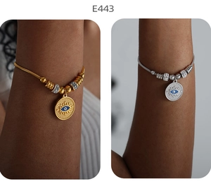 Nahaufnahme von gold- und silberfarbenen Evil Eye Perlenarmbändern mit Kristallcharms