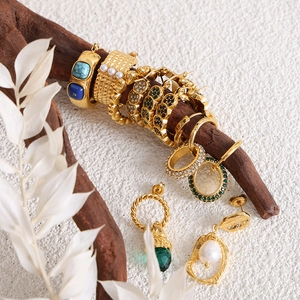 Parure de bijoux en titane doré avec perles et gemmes sur décor en bois naturel élégant