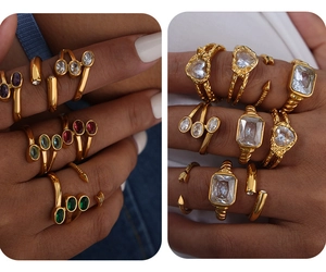 Dettaglio di anelli vintage in vetro smeraldo dorato con set di gemme miste