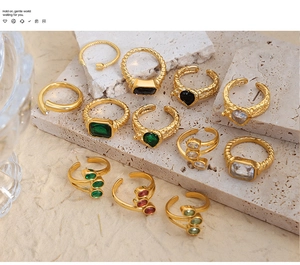 Dettaglio di anelli vintage in acciaio al titanio placcato oro 18k con smeraldo e rubino