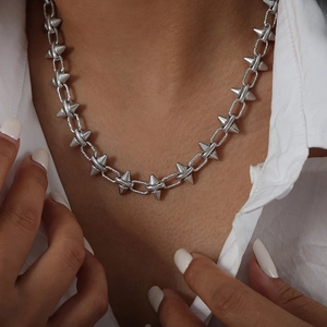 Punk style silver choker necklace with chunky rivet links on white shirt