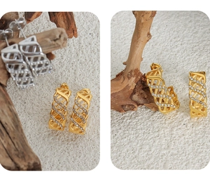 Close-up of geometric hollow C-shaped earrings with crystals in gold and silver finish