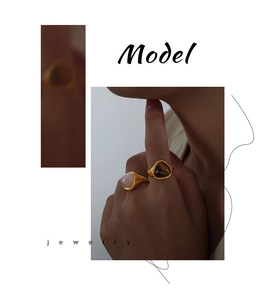 Close-up of golden triangular rings with natural rose quartz and tiger eye stones