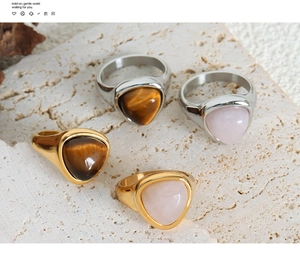 Macro detail of gold and silver titanium steel rings with natural tiger eye and quartz