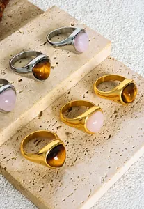 Detailed view of stainless steel signet rings with tiger eye and rose quartz stones
