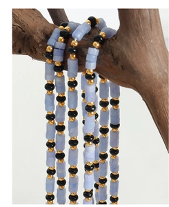 Détail du collier avec perles cylindriques mauves, onyx noir et intercalaires dorés