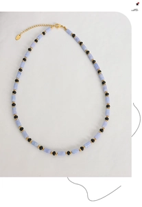 Détail du collier de perles cylindriques bleues et noires avec fermoir doré poli