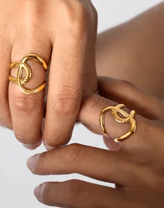 Detail eines goldenen Doppelrings mit glatter und gedrehter Seilstruktur an der Hand