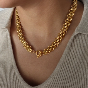 Collier à double chaîne dorée épaisse avec fermoir à bascule OT sur un modèle en maille