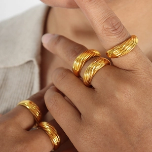 Anelli d'oro in stile vintage francese con trama a spirale indossati in un set a strati