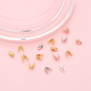 Macro shot of gold, silver, and rose gold jewelry crimp covers for DIY necklace craft