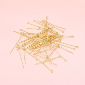 Chiodini a occhiello in oro 14K per gioielli fai-da-te su sfondo rosa tenue