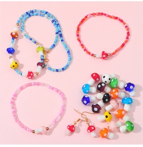 Flat lay of colorful mushroom beads jewelry set with necklaces and bracelets on pink background