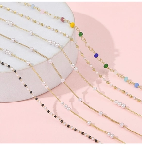 Macro shot of gold-plated chains with pearls and gemstones for DIY jewelry making