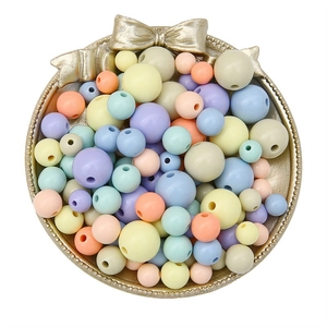 Assorted macaron colored acrylic round beads for DIY jewelry making in a golden tray