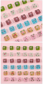 Macro detail of square frosted glass beads with hand-painted floral patterns and dots