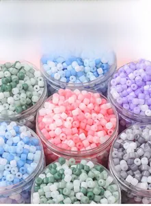 Close-up of colorful acrylic cylinder beads in transparent jars for DIY jewelry making