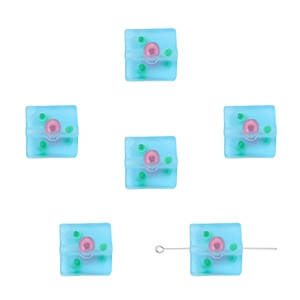 Macro view of light blue frosted glass cube beads with pink core for DIY jewelry