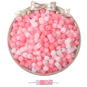 Pink and white cylindrical acrylic beads for DIY jewelry making in a silver tray