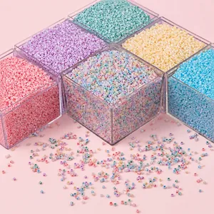 Macro detail of colorful macaron glass beads in a transparent organizer box for DIY jewelry
