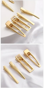 Detail van diverse 14K vergulde geometrische haarspelden op elegante witte zijden stof