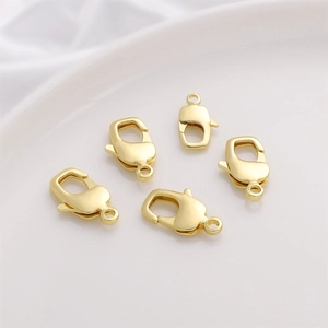 Five 14K gold plated lobster clasps for DIY jewelry making on white ceramic tray