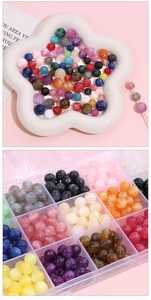 Macro shot of assorted 8mm glitter resin beads for DIY jewelry making in a divider box