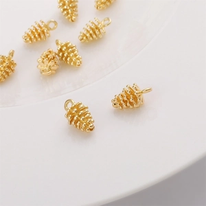 Polished 14k gold-plated pine cone pendants for DIY jewelry making on white background