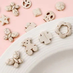 Detailed close-up of white turquoise charms in various shapes for DIY jewelry making