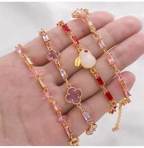 Détail de bracelets plaqués or 14K sertis de zircons colorés et de pendentifs variés