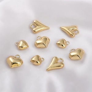 Various 14K gold filled heart pendants for DIY jewelry making on white silk fabric