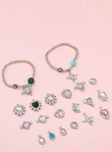 Detail of Y2K DIY jewelry kit with silver heart, star, moon charms and beaded bracelets