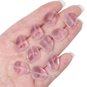 Macro detail of 12x15mm matte pink glass beads showing size and texture in hand