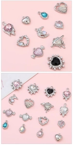 Detail showing Y2K style heart and moon pendants with silver metal and colorful gemstones