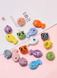 Macro shot of colorful ceramic beads in panda and fish shapes for DIY jewelry making