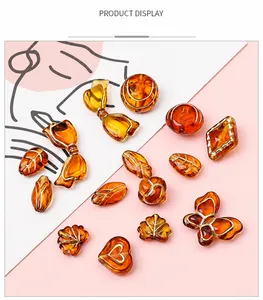 Détails de perles en acrylique ambré avec contours dorés en forme de papillon et cœur