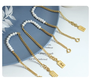Detail van Britse parelarmband met koningin munt en goudstaaf hangers in 18K afwerking