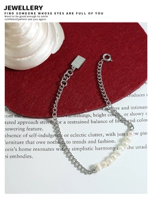 Detail van de zilveren titanium stalen armband met zoetwaterparels en queen hanger