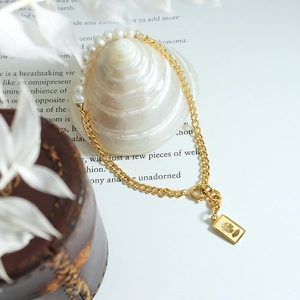 Vintage armband met parels en een gouden hanger met een koninklijk portret erop