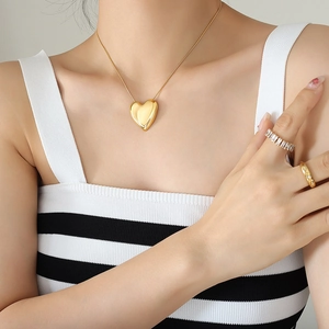 Golden hollow heart pendant necklace with zircon rings set worn by a fashion model