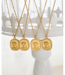 Nahaufnahme von vier goldenen Vintage-Anhängern mit Rosenrelief und kleinen Kristallen