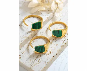 Detailed shot of three golden adjustable rings with green malachite textured stone insets