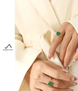 Detail showing two gold stainless steel rings with green striped malachite texture inlay