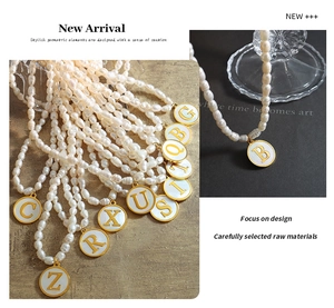 Macro view of natural freshwater pearl necklaces with gold initial shell pendants