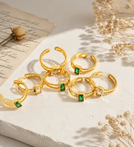 Detail of vintage gold twisted rings with emerald and clear rectangular gemstones