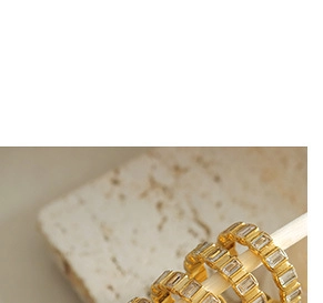 Macro shot of gold-plated rings with channel-set baguette cut clear cubic zirconia crystals